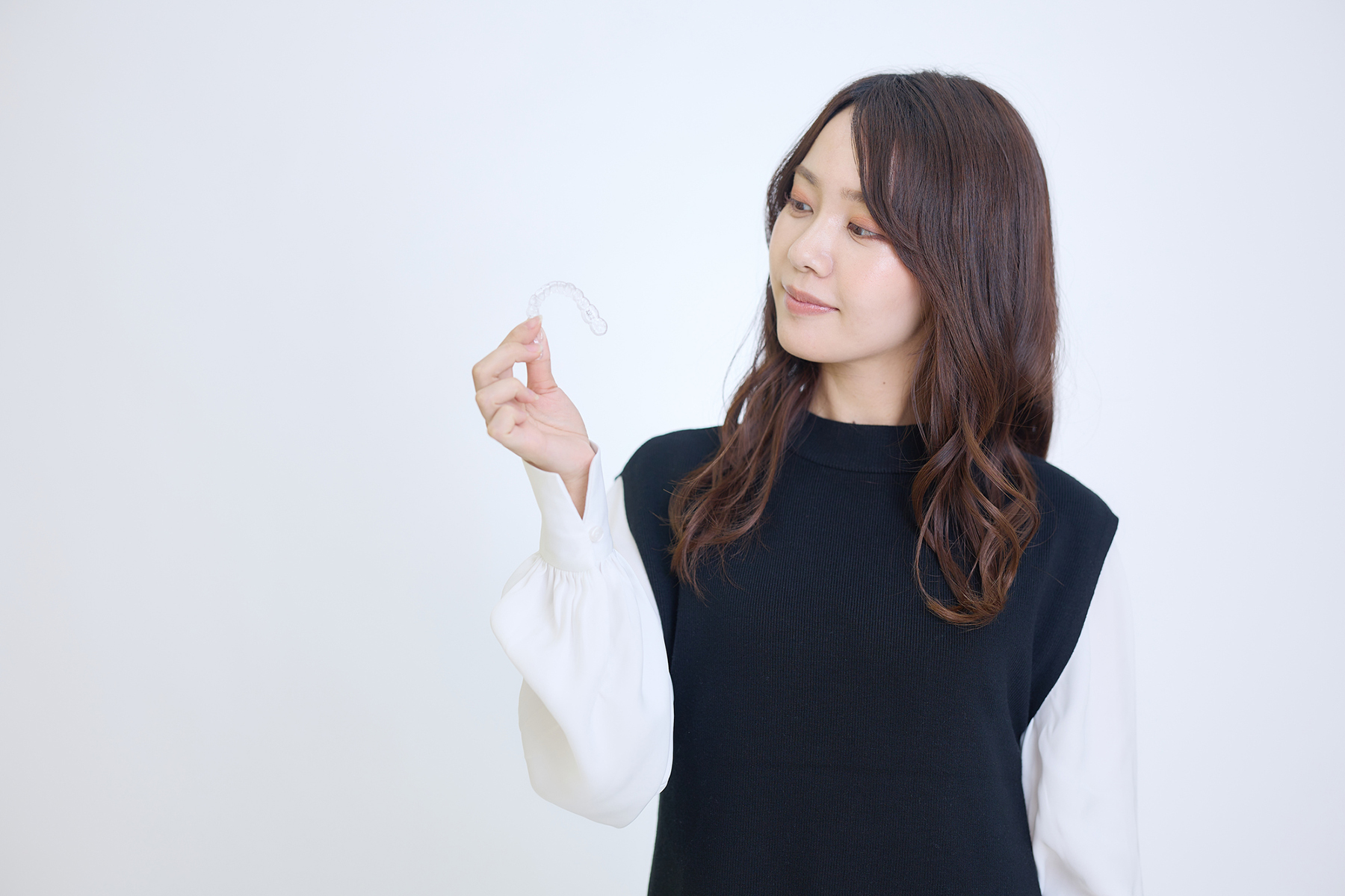 マウスピース矯正を持つ女性