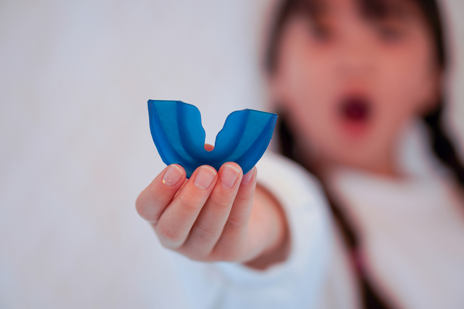 子どもが青いママウスピースを手に持っている様子