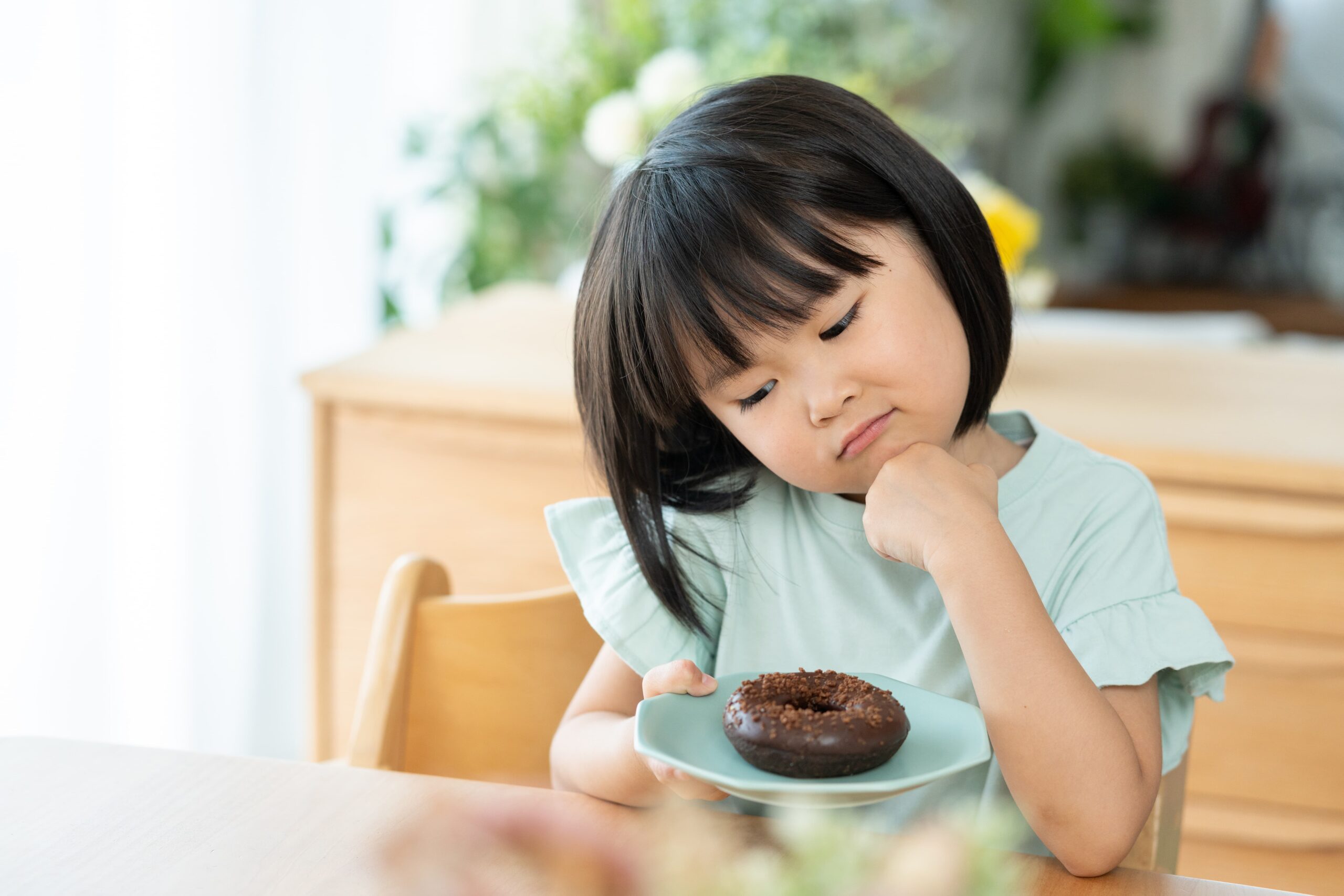 虫歯予防の為に、お菓子を食べるか悩んでいる女の子