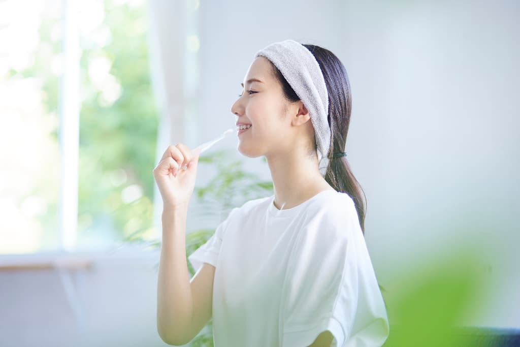 歯の矯正を計画どおりに進めるために歯磨きを徹底する女性