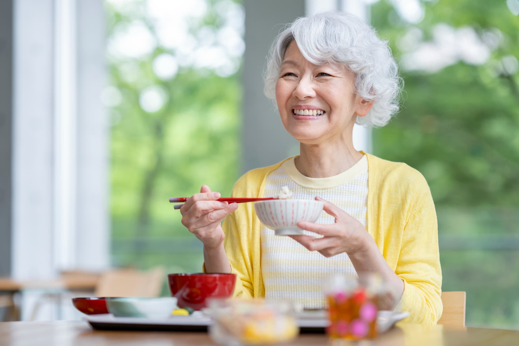 自分に合った入れ歯を装着しおいしく食事をいただく女性