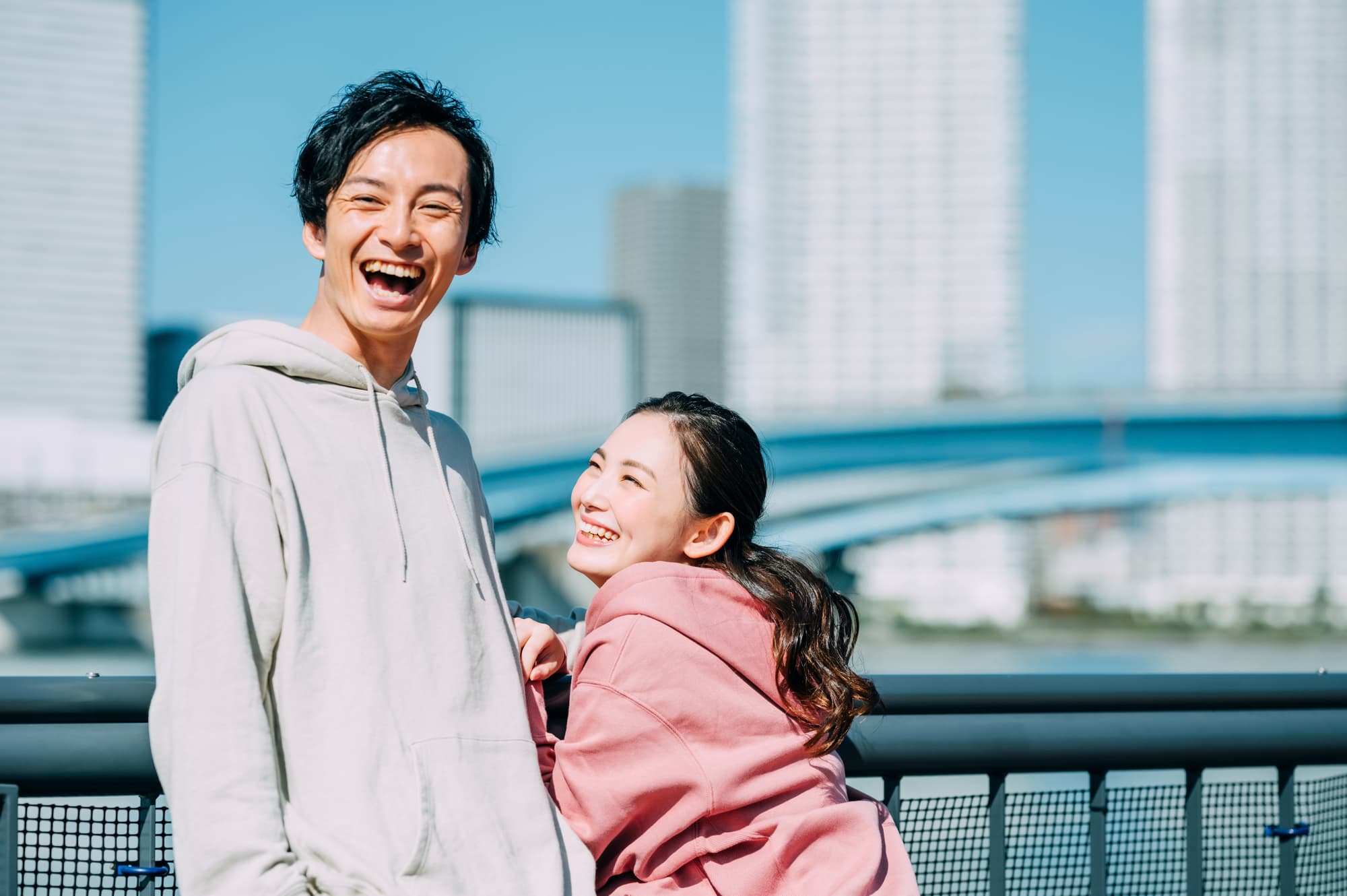 青空の下で笑顔の男女