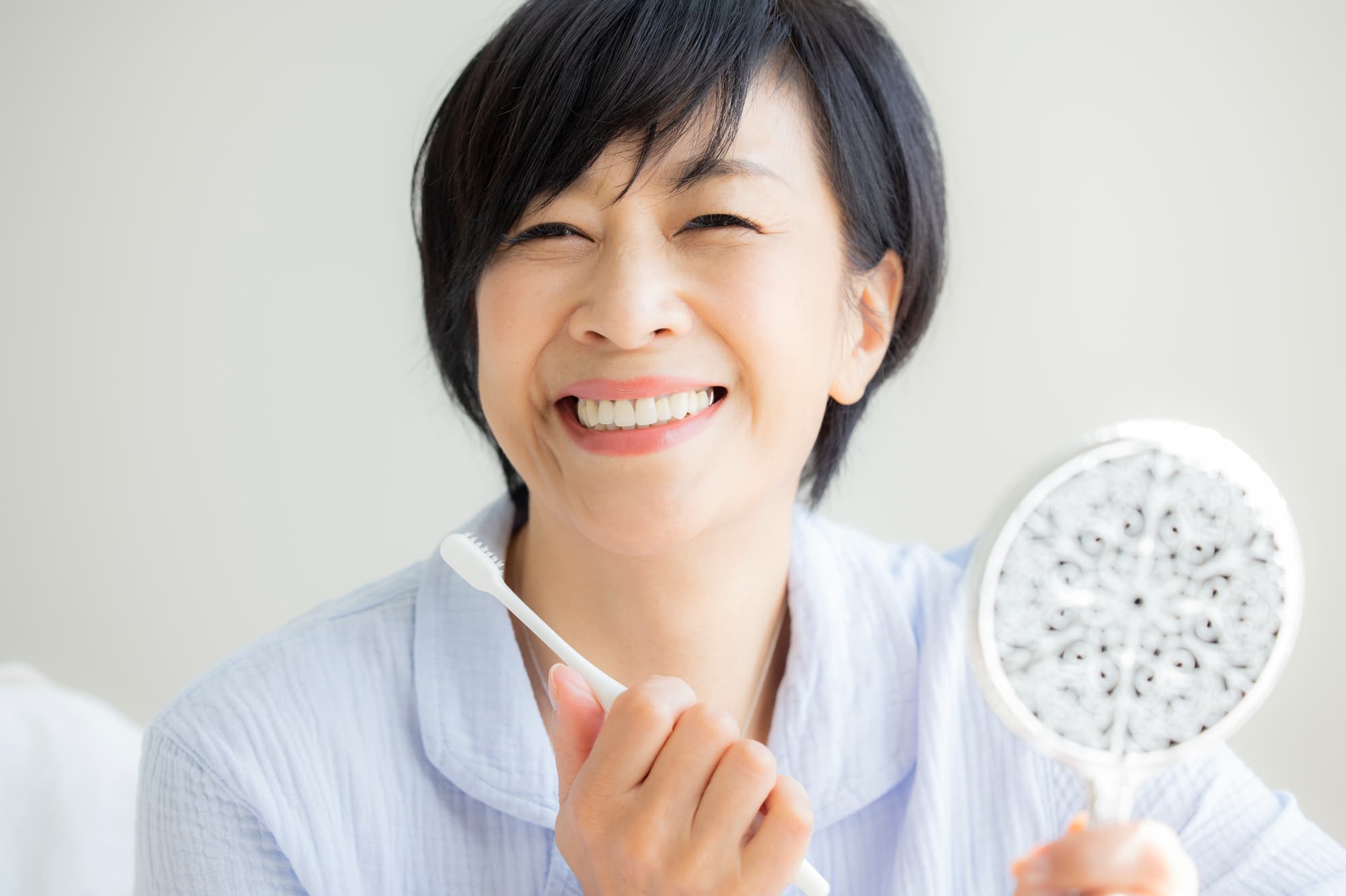 インプラント治療後の口臭を防止する為に歯みがきを丁寧にする女性