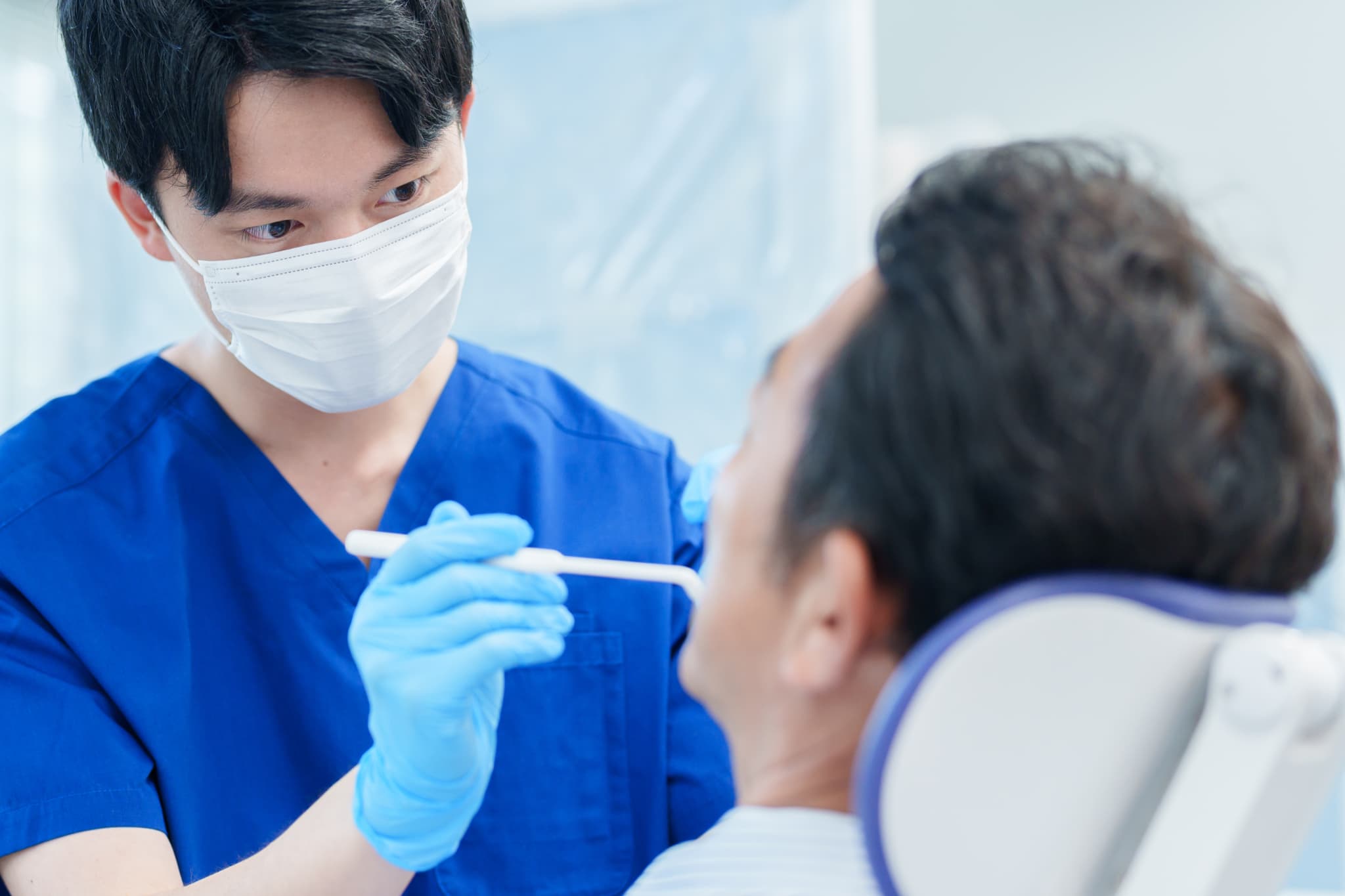 インプラントや歯ぐきの状態を確認する歯科医師