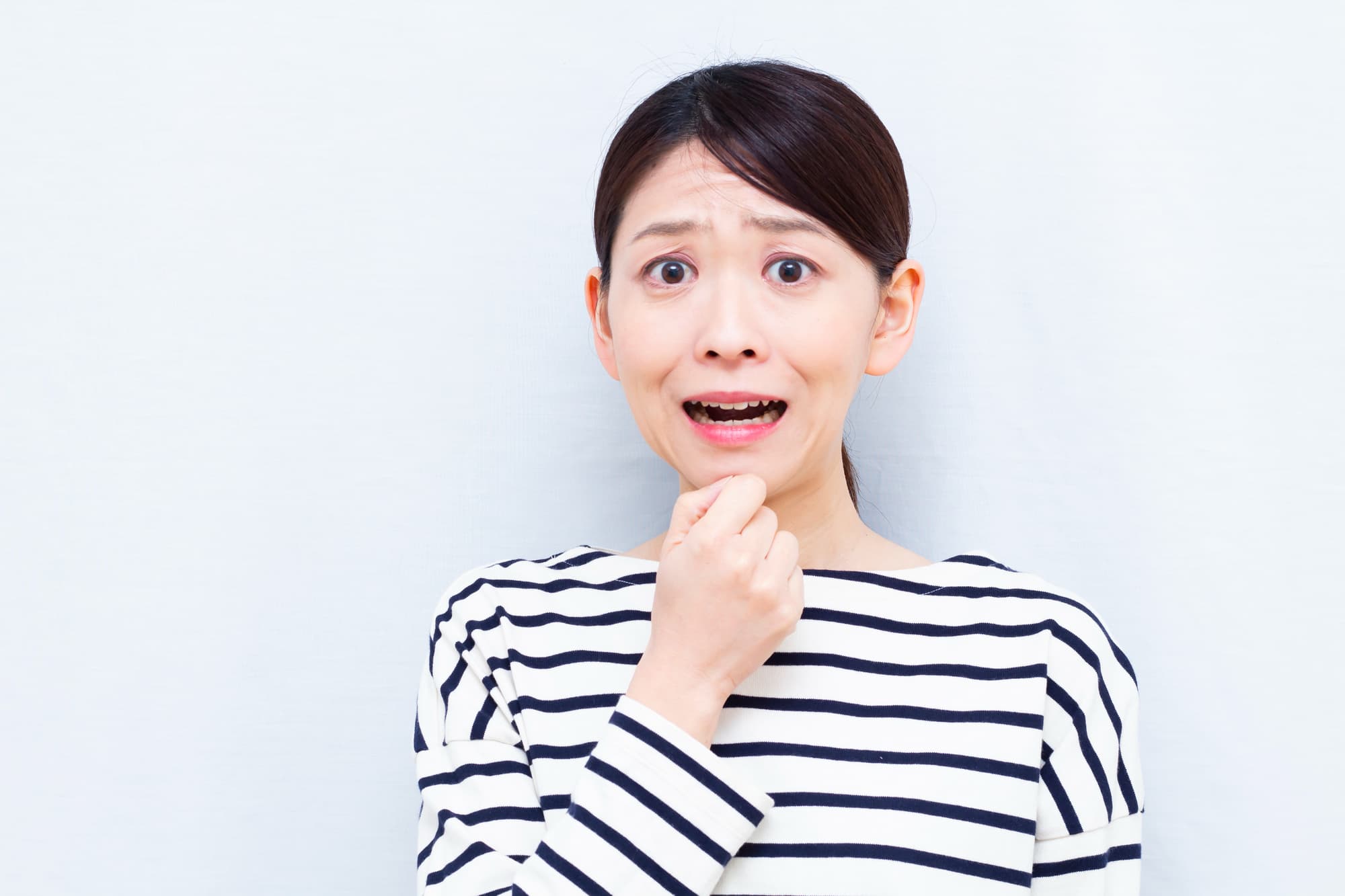 セラミックの歯が取れて驚く女性